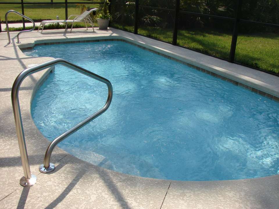 Ein ruhiges Bild eines sauberen Swimmingpools in einem sonnigen Hinterhof, perfekt zum Entspannen.