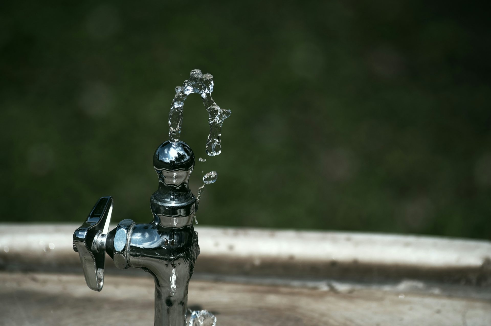 silberner Wasserhahn mit Wassertropfen